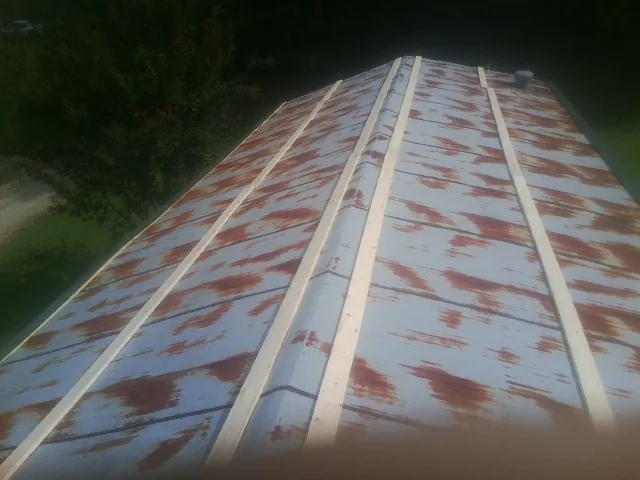 Rusted metal roof panels with new wood purlins before replacement — Storm Damage Roof Repair in Batchelor by Roofing Brothers