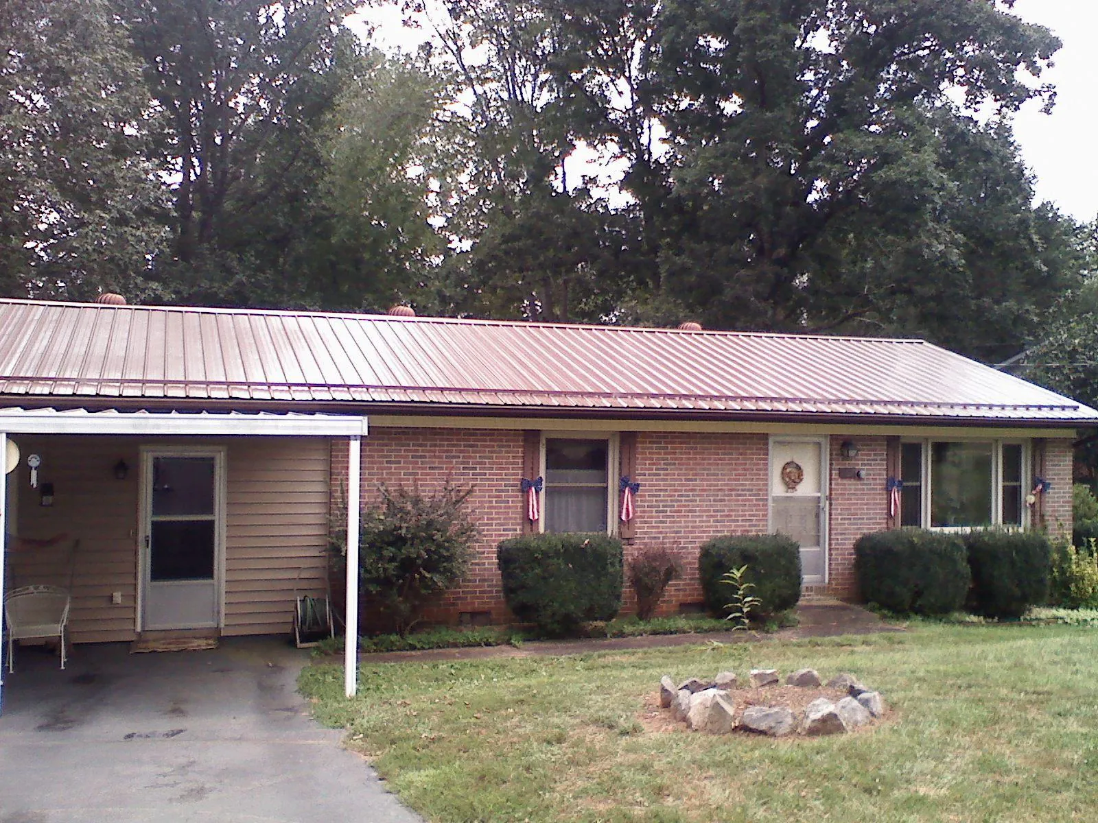 Bronze metal roof and carport on a brick ranch home — Roof Repair work by our crew in Batchelor